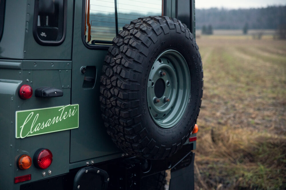 Green off-road vehicle with spare tire in field