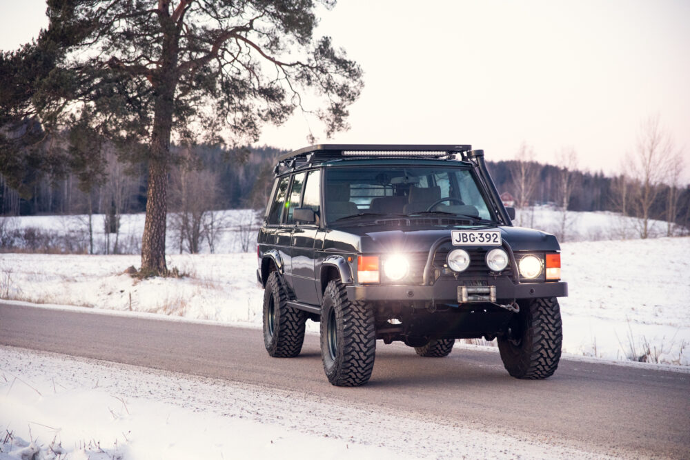 Black SUV driving on snowy rural road