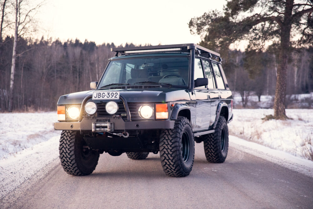 Modified SUV driving on snowy forest road