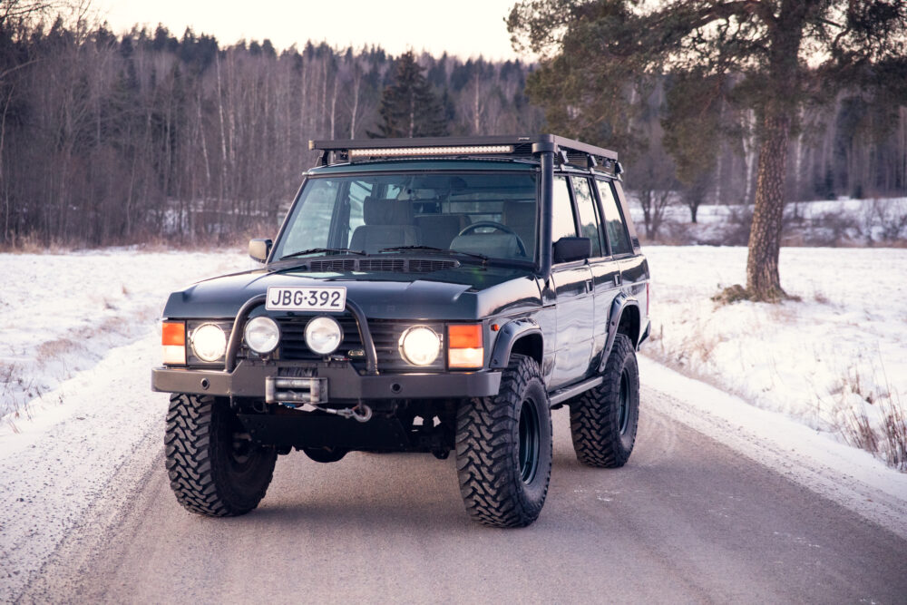 Black SUV driving on snowy forest road