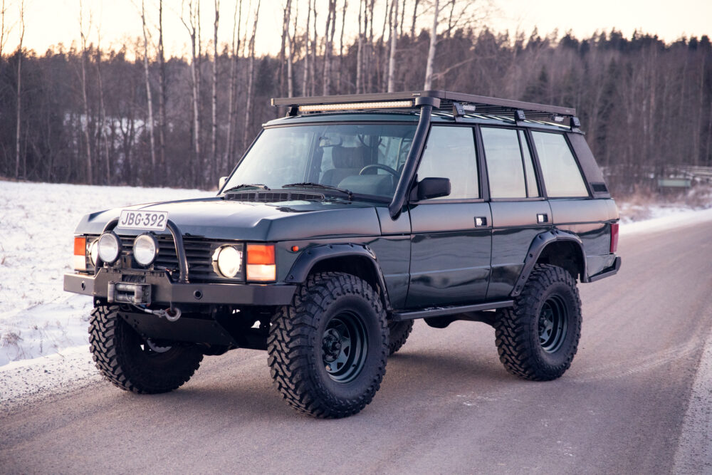 Black off-road SUV on snowy roadside at dusk