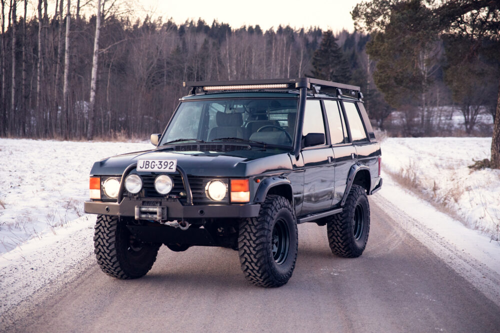 Vintage SUV on snowy forest roadside