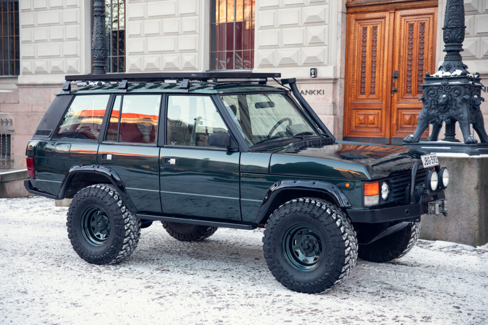 Green off-road vehicle parked in snowy urban setting