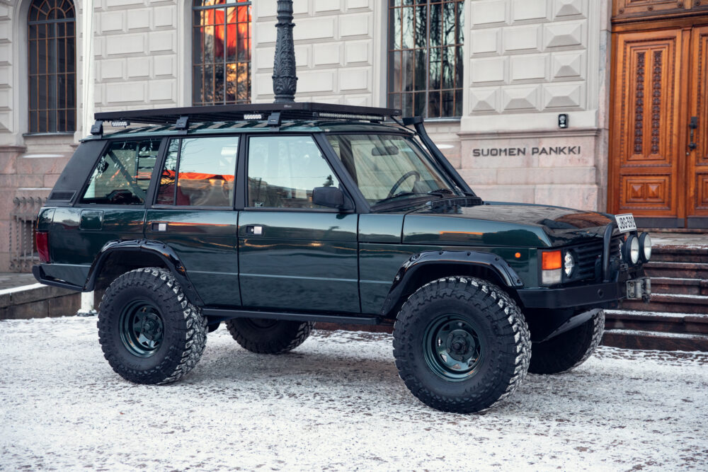 Modified off-road vehicle parked near stone building entrance