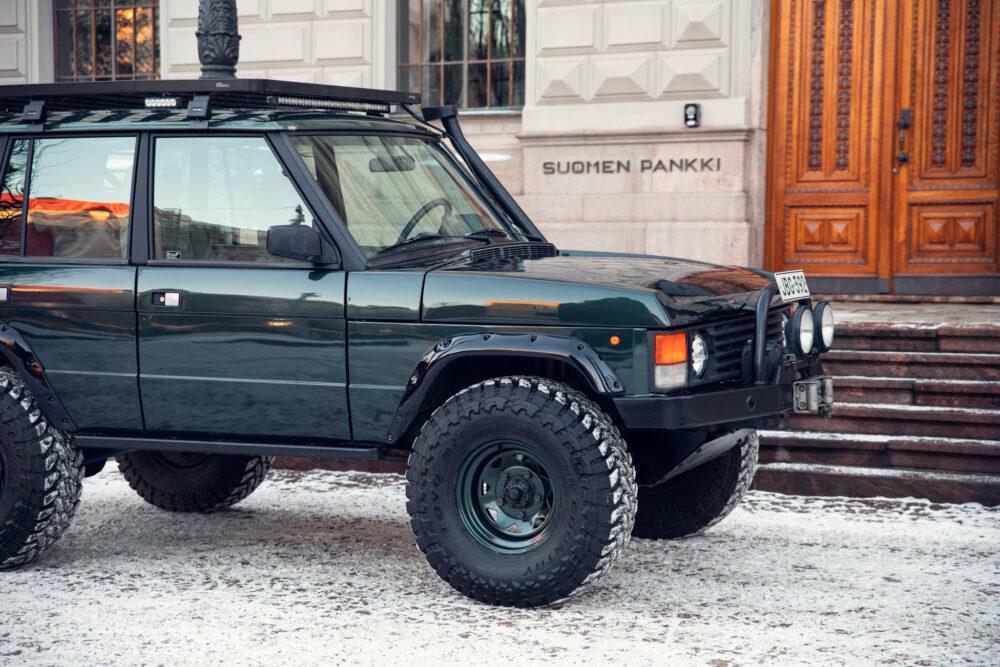 Green SUV parked near Finnish Bank in snowy street