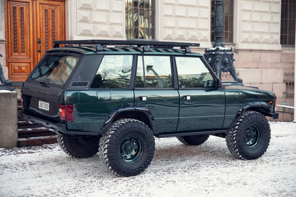 Green off-road SUV parked on snowy street