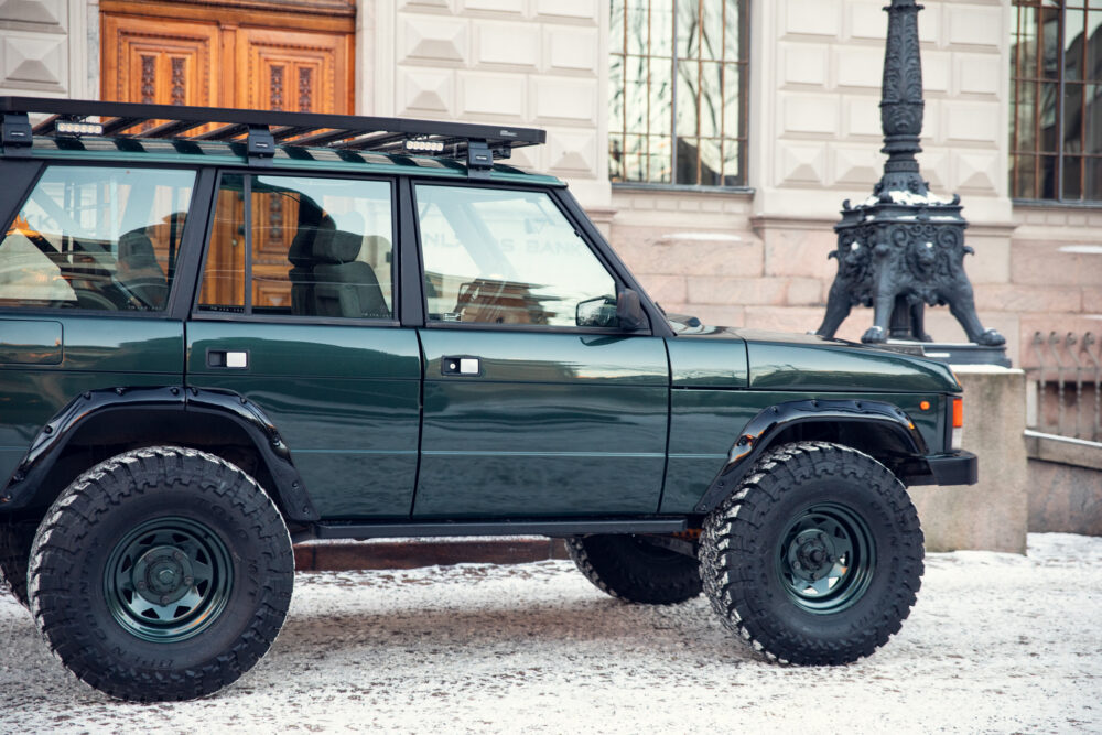 Green off-road vehicle parked on snowy city street