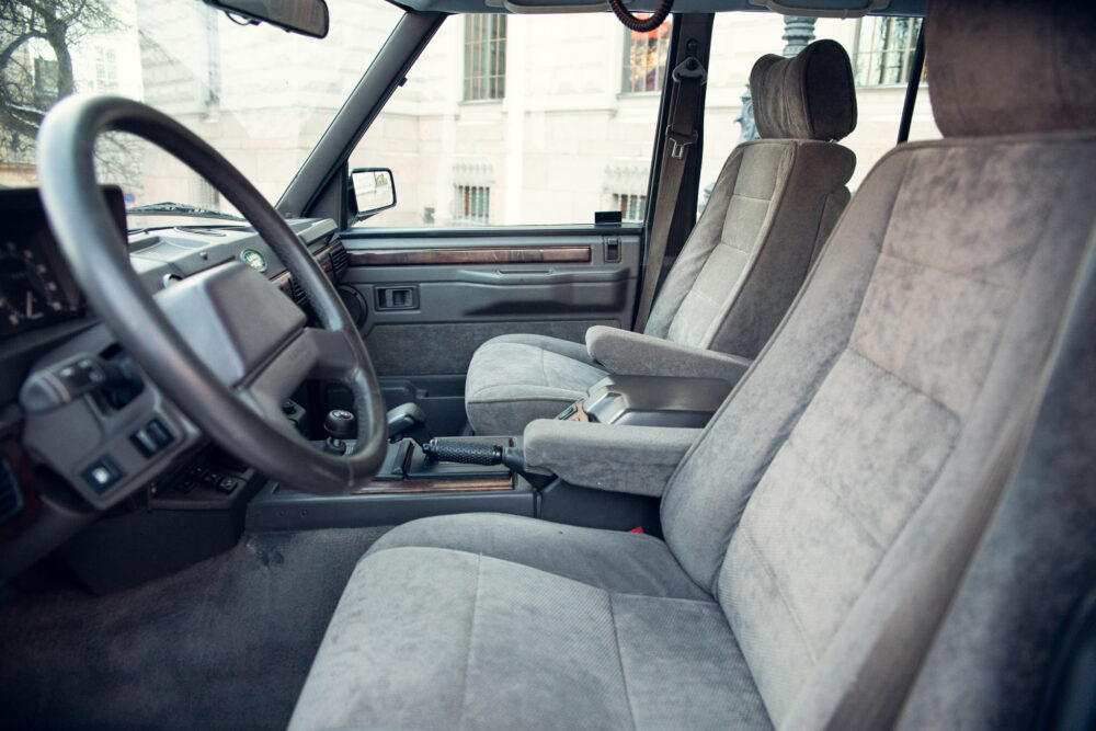 Vintage car interior with gray fabric seats and dashboard