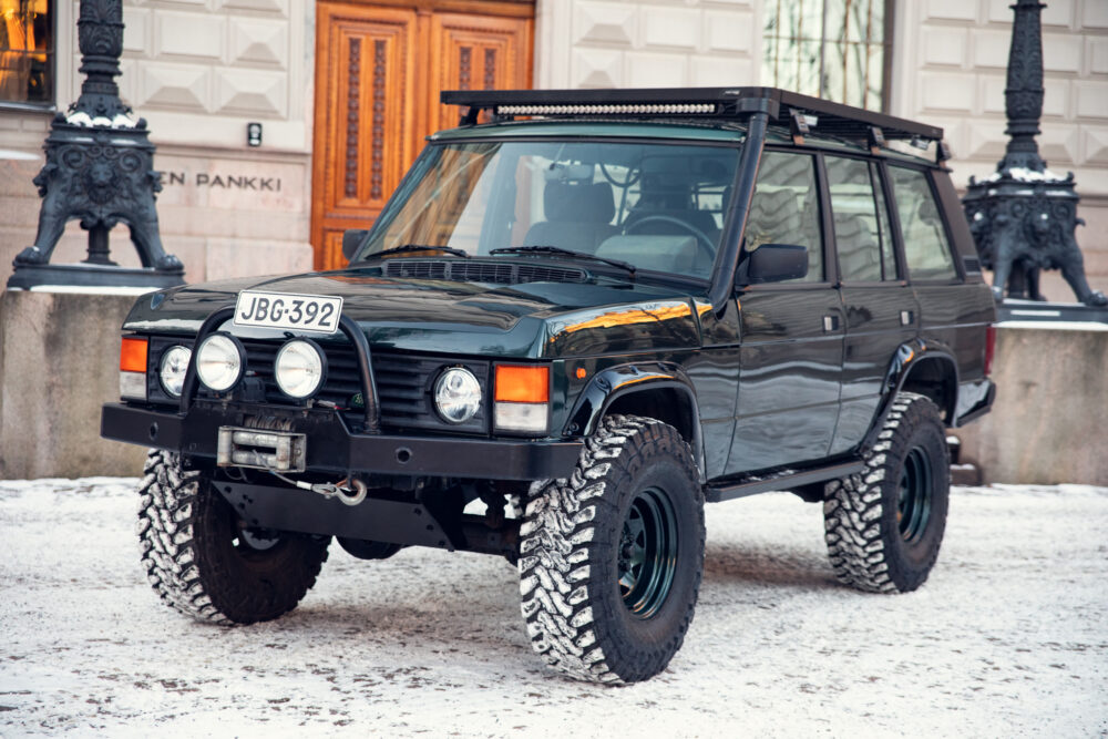 Black SUV parked on snowy road near building