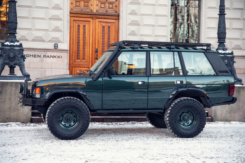 Rugged green SUV parked on snowy street near building