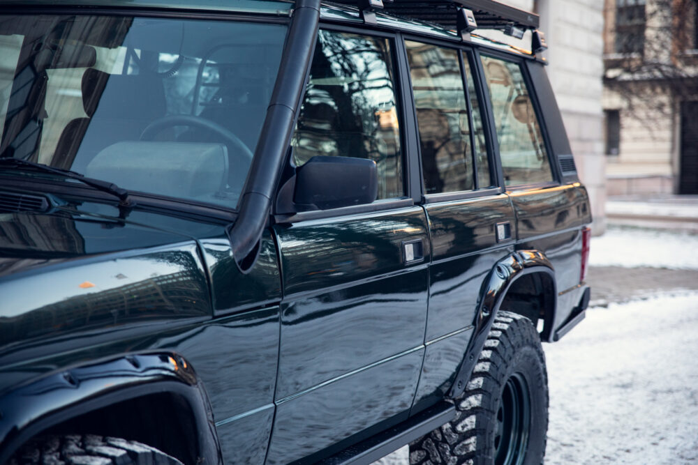 Green SUV with off-road modifications parked outdoors