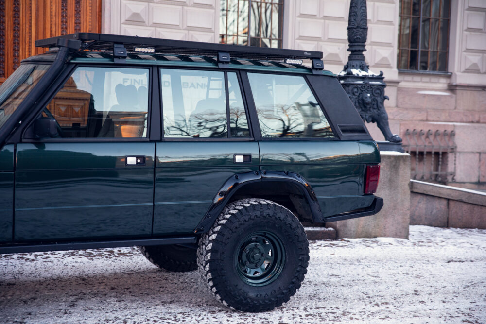 Green SUV parked on snowy urban street