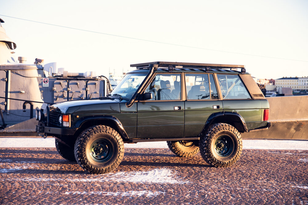 Modified off-road vehicle parked near urban waterfront