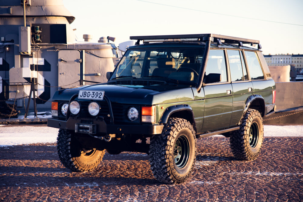 Vintage off-road vehicle parked near naval ship