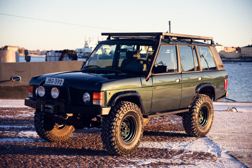 Vintage SUV parked on snowy pier at sunset