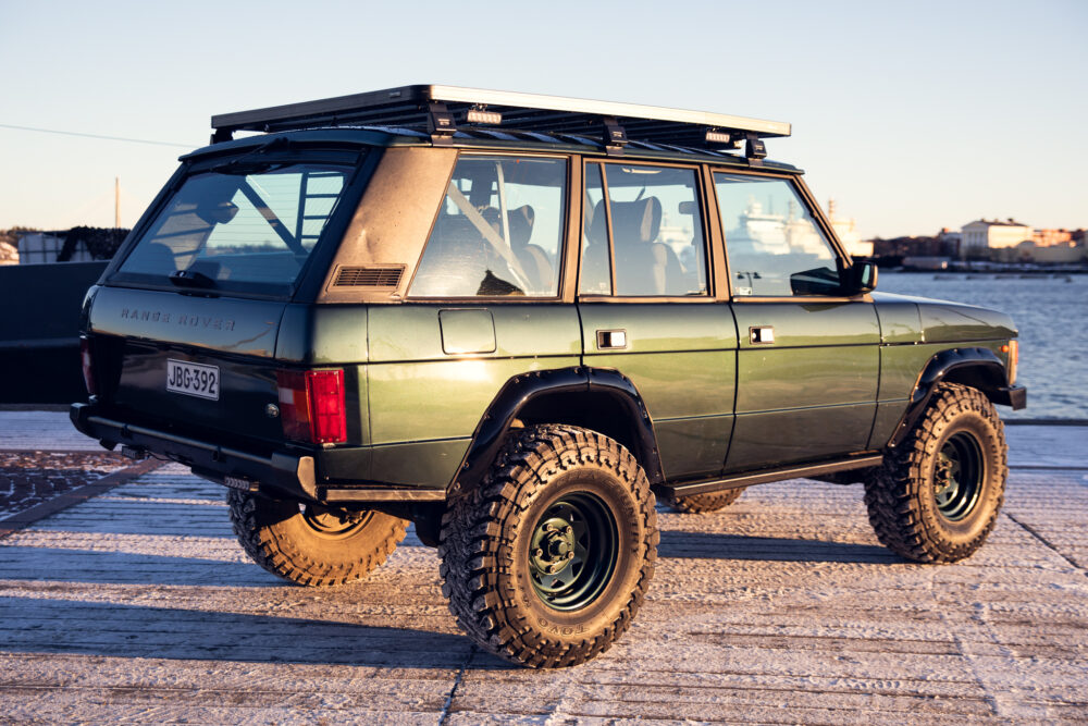 Vintage green Range Rover parked on cobblestone dock