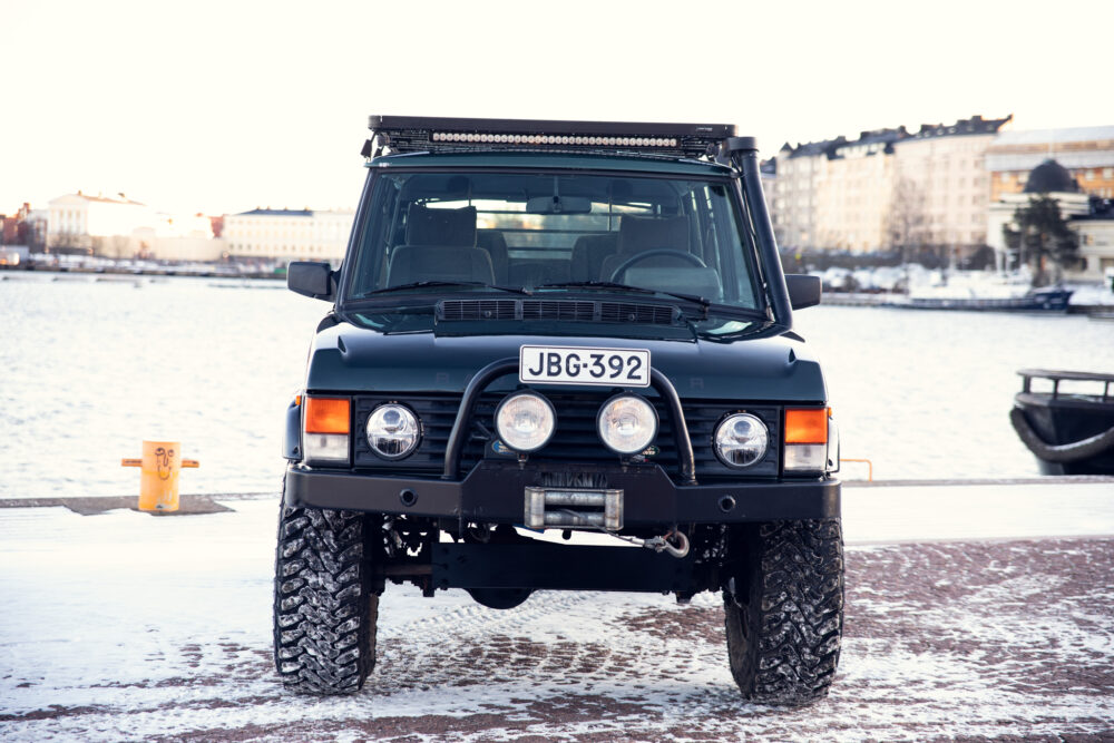 Black off-road vehicle on snowy dock near water