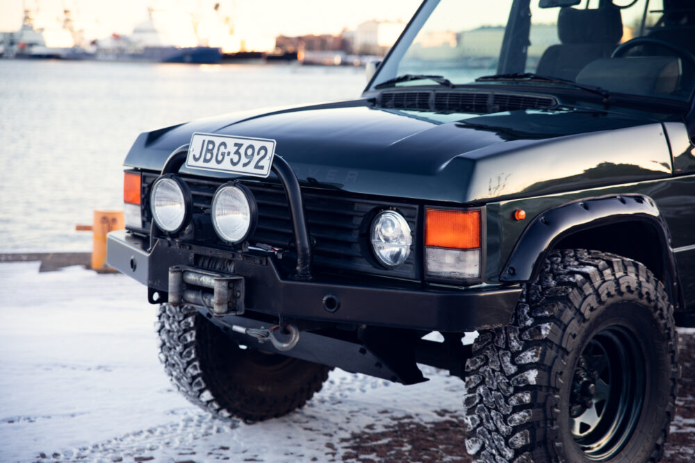 Black off-road vehicle with snow chains near harbor