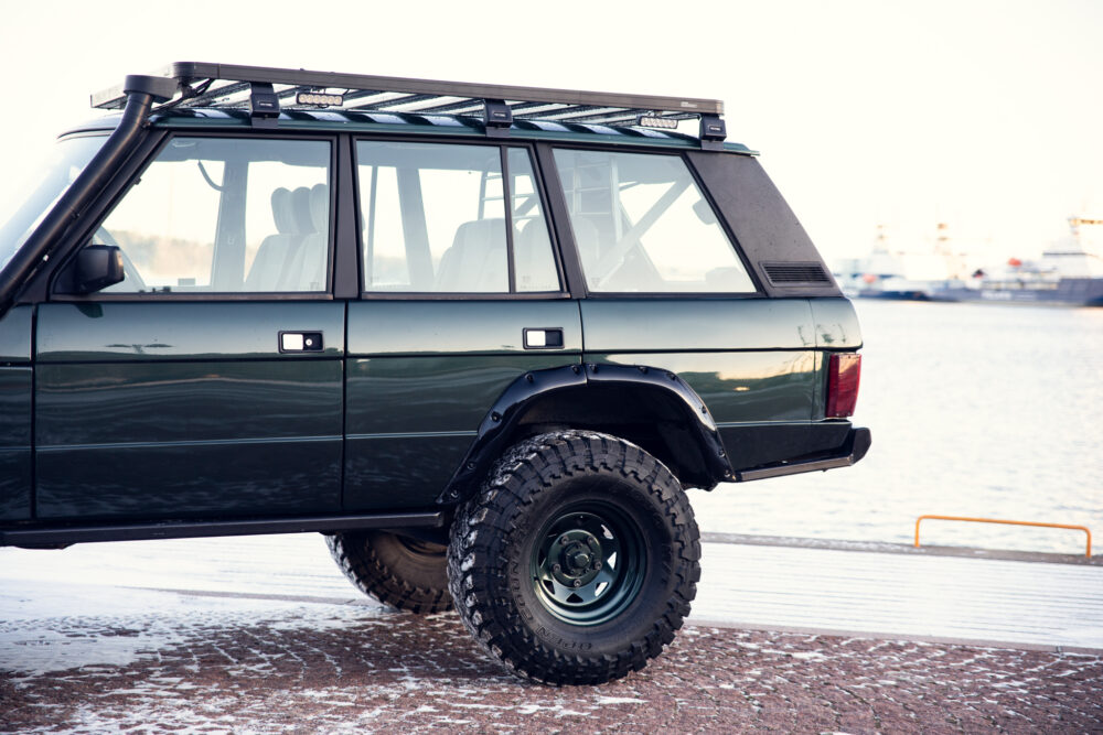 Green SUV by snowy dock with roof rack