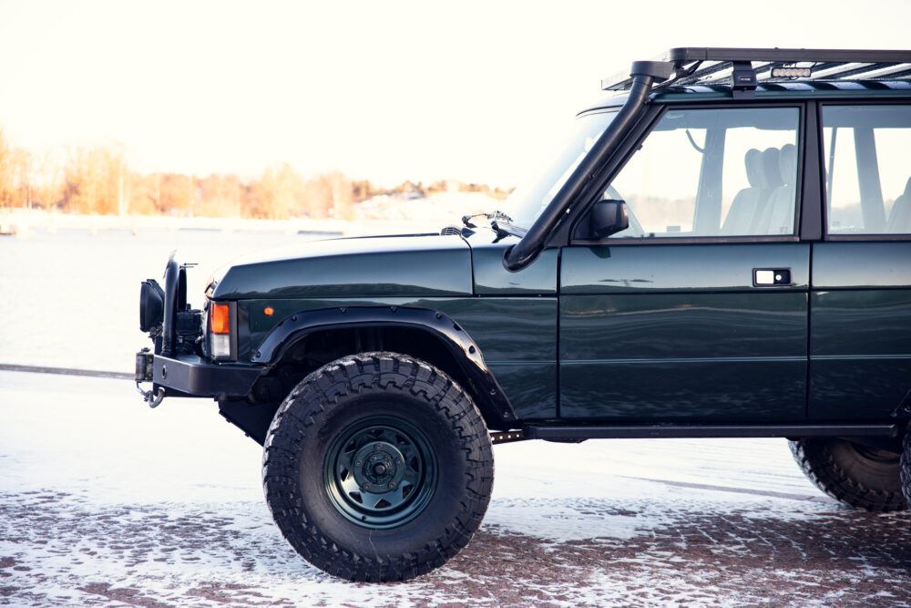 Green off-road vehicle on snowy lakeside