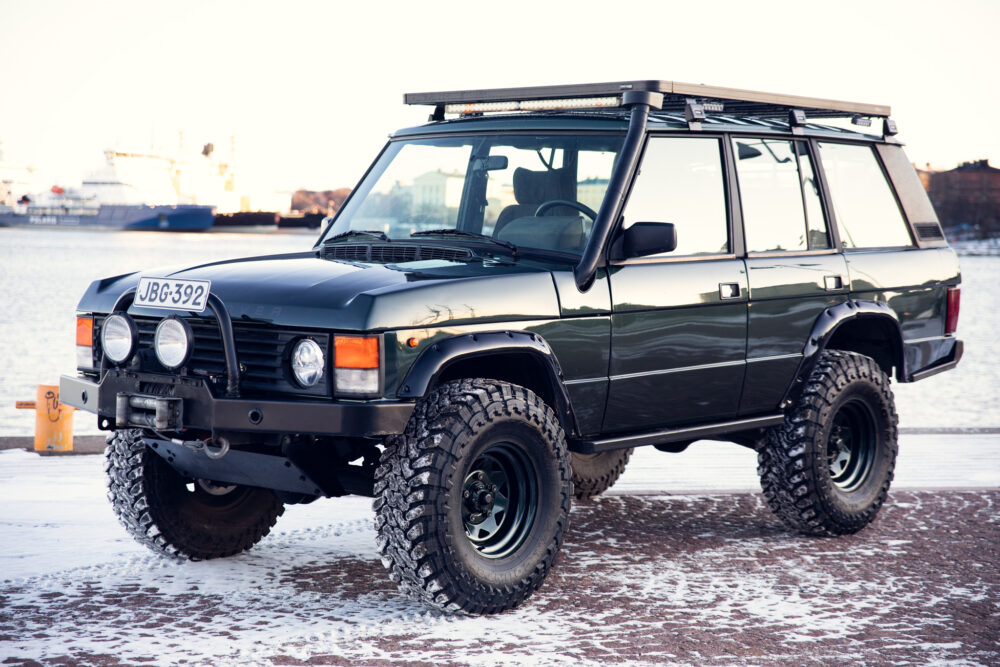 Modified dark green off-road vehicle in snowy dock