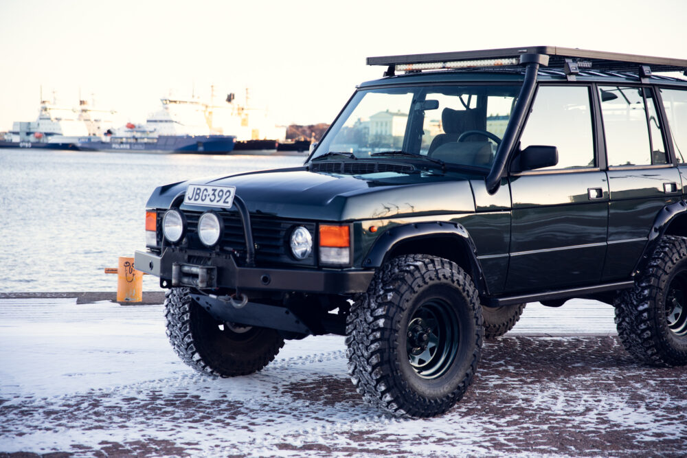 Black off-road vehicle by snowy harbor