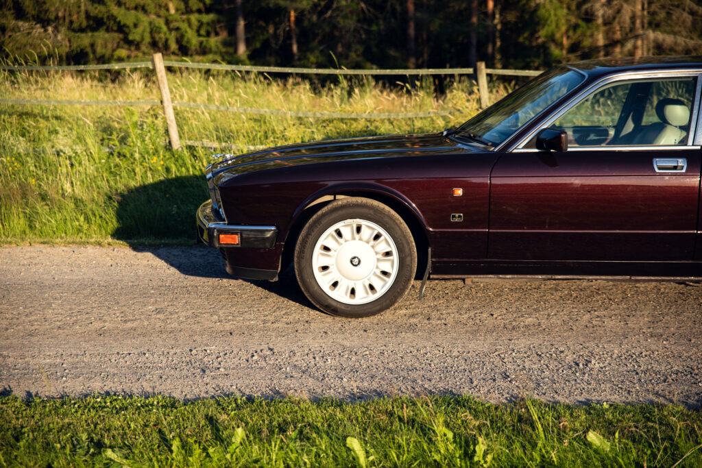 Classic maroon sedan parked on rural gravel road