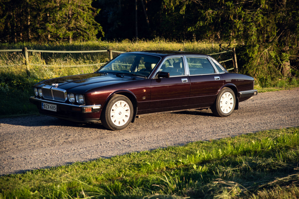 Classic maroon luxury sedan on rural road