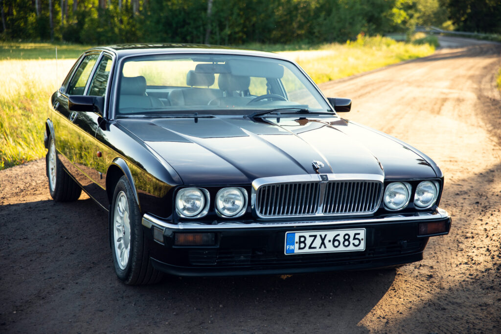 Black Jaguar XJ on rural dirt road