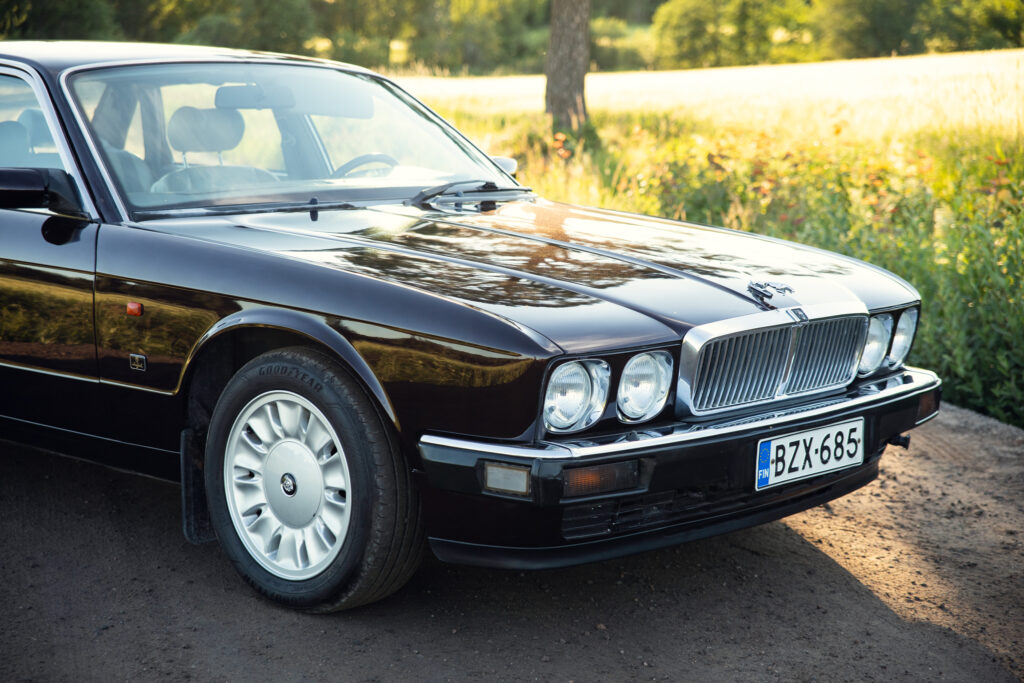 Classic black luxury sedan on country road