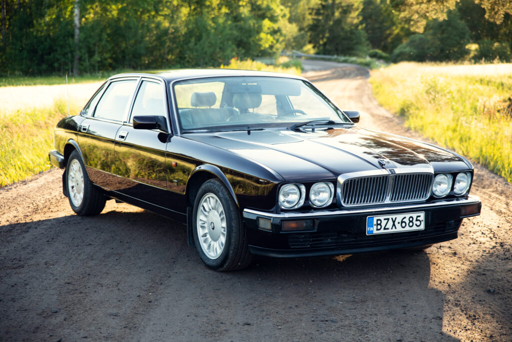 Classic black luxury sedan on country dirt road