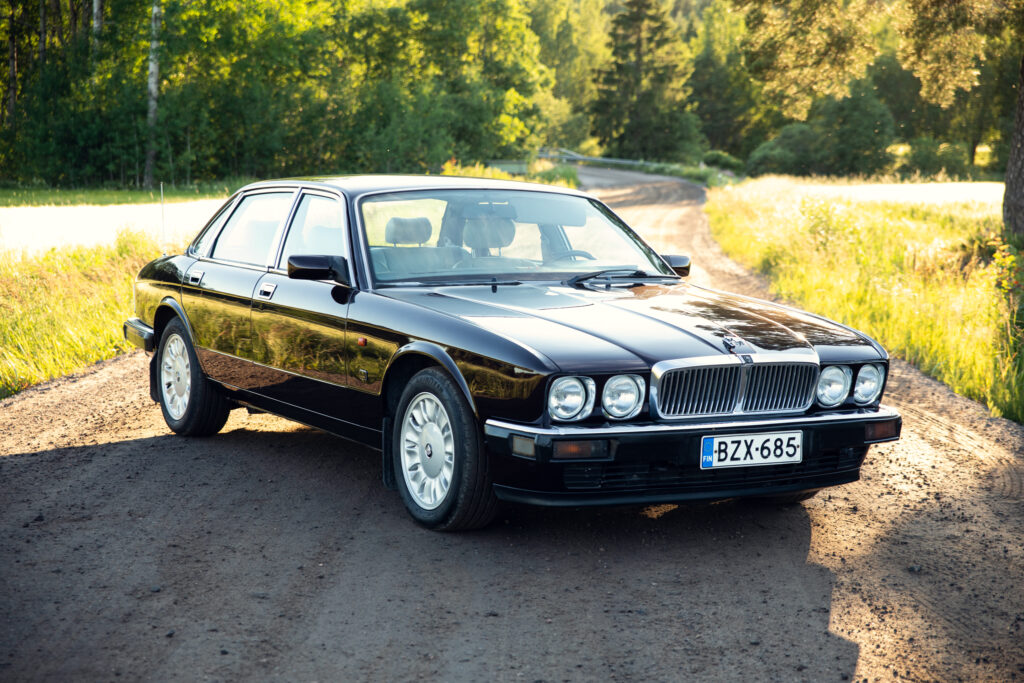 Black vintage luxury sedan on rural road