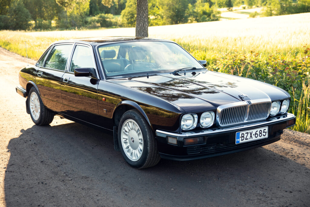 Black classic Jaguar sedan on country road
