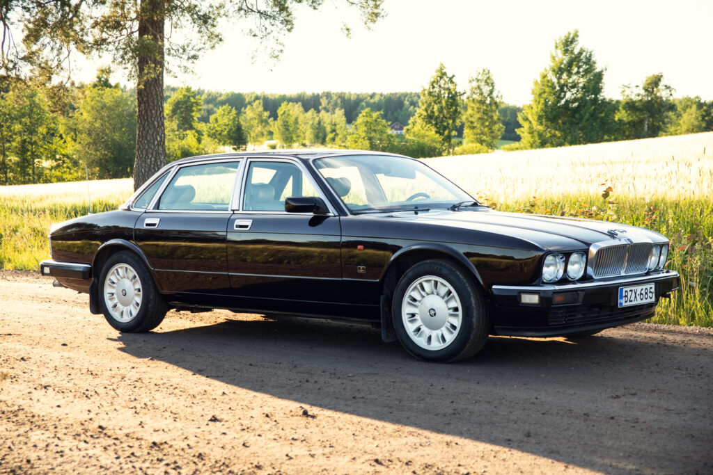 Black classic luxury sedan on rural road