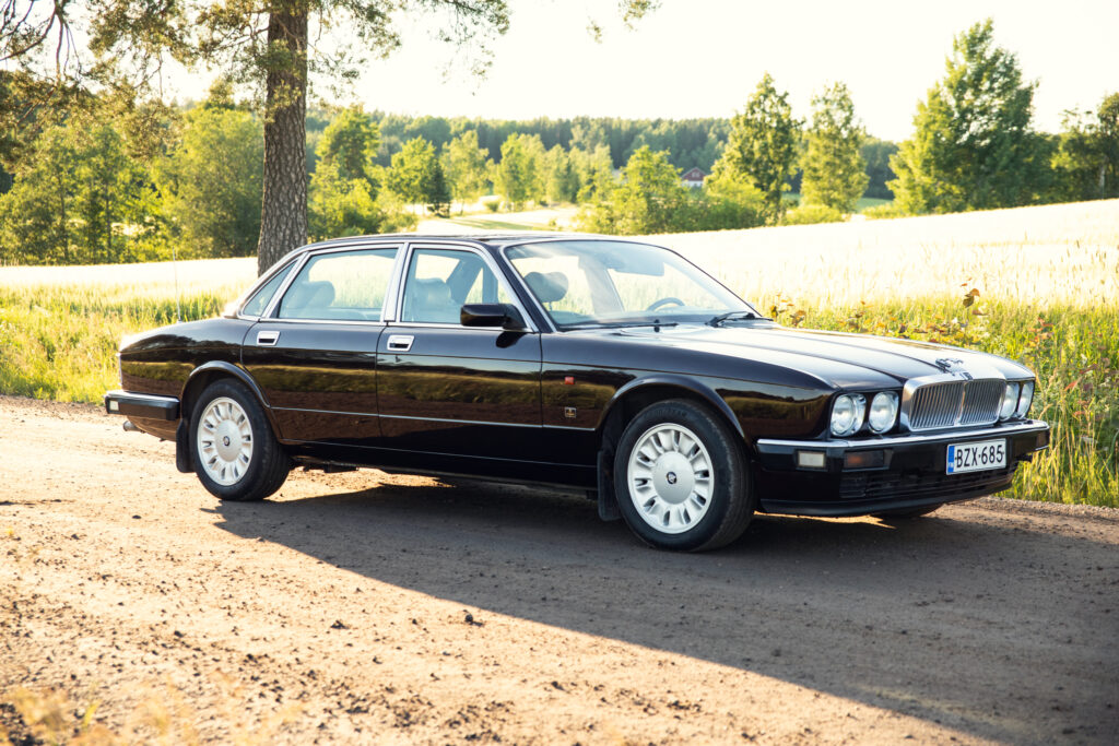 Classic black Jaguar sedan on country road
