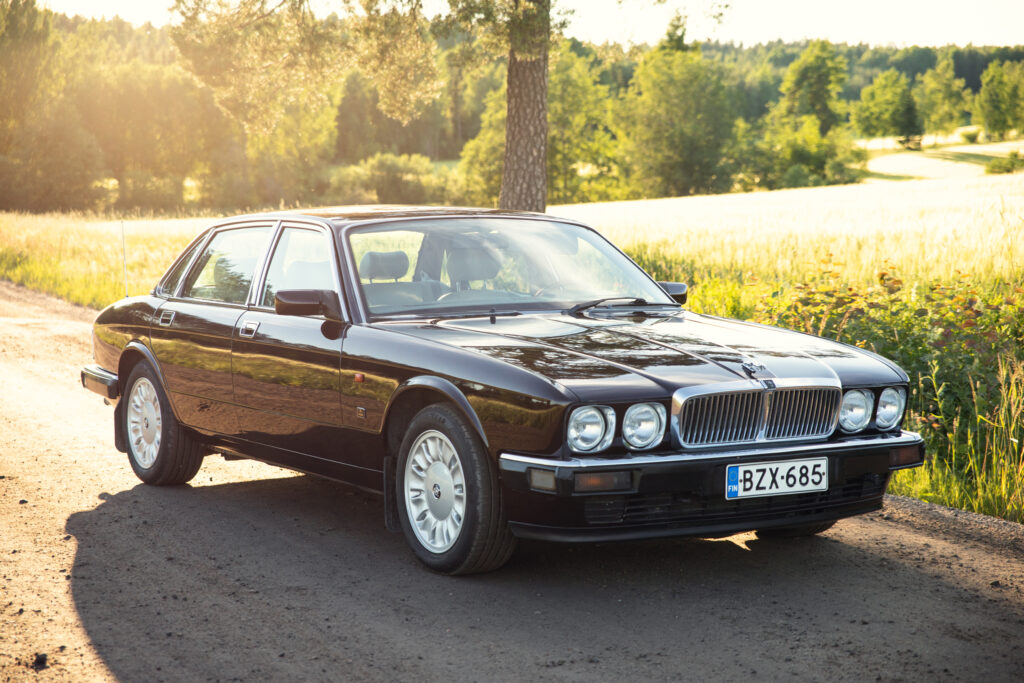 Black classic Jaguar sedan on rural road