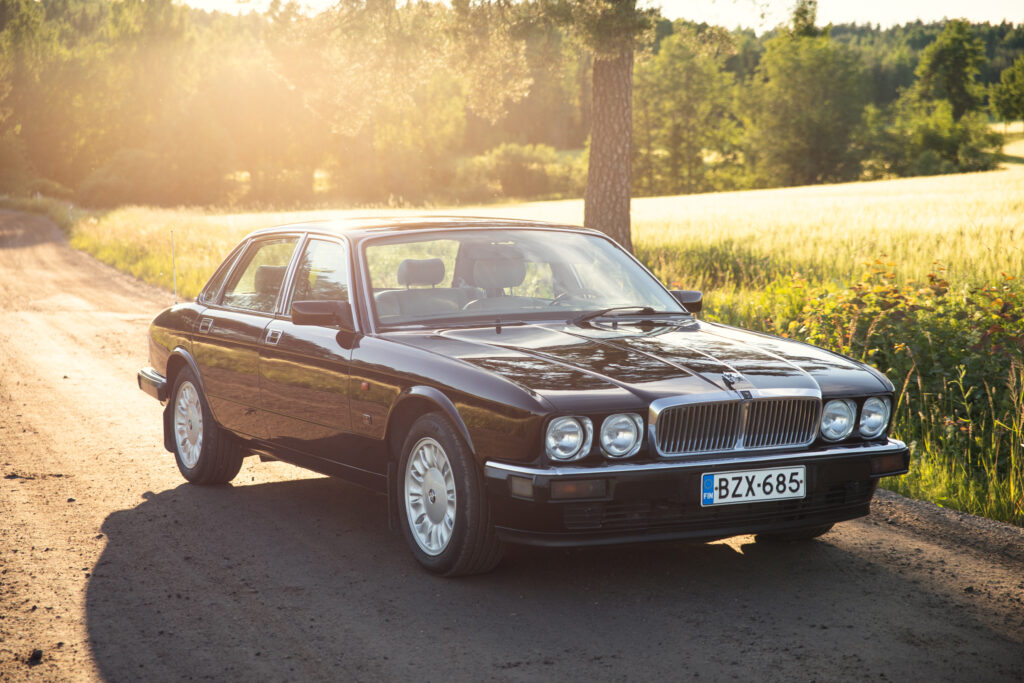 Classic black Jaguar sedan on rural dirt road
