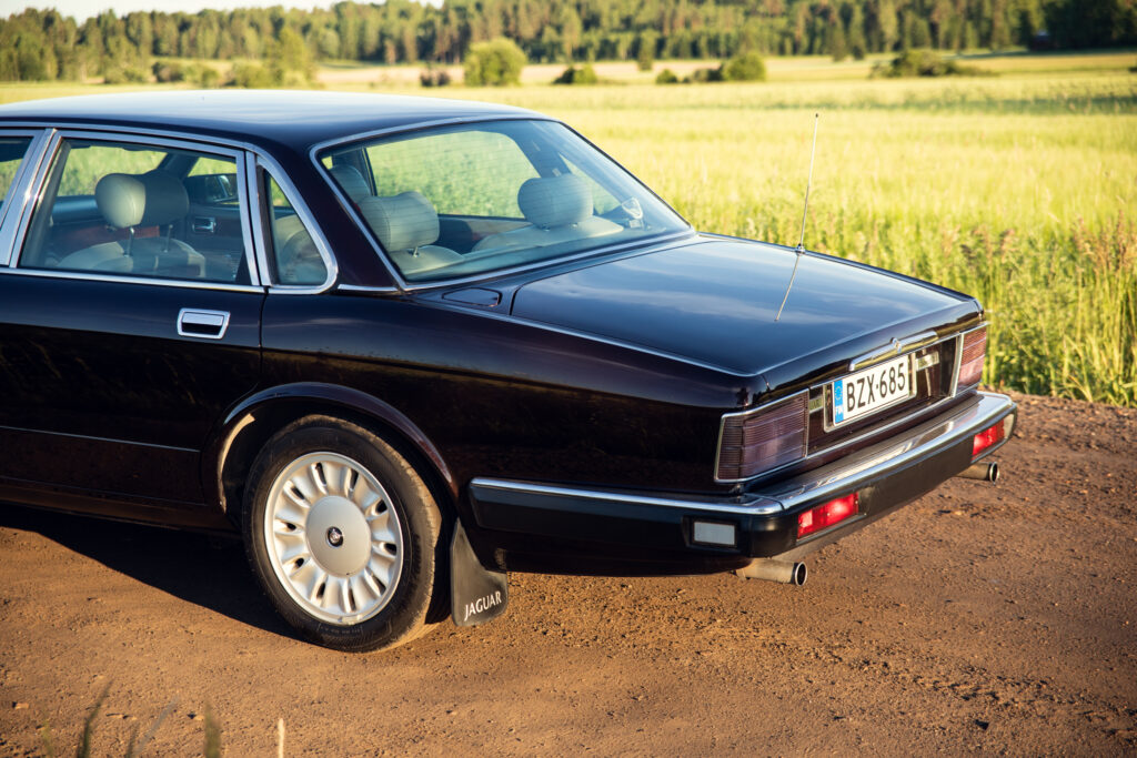 Black Jaguar sedan parked on rural dirt road