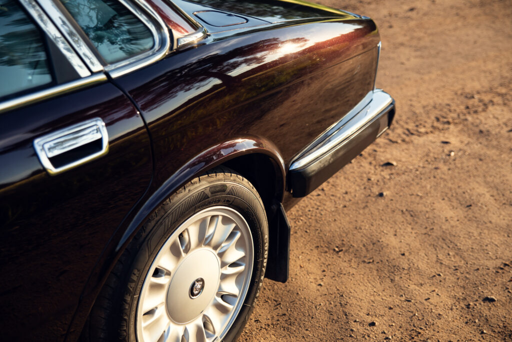 Close-up of vintage Jaguar rear wheel and body
