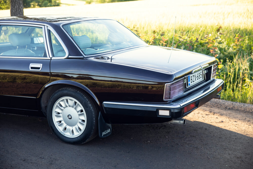 Classic black Jaguar sedan parked by lakeside