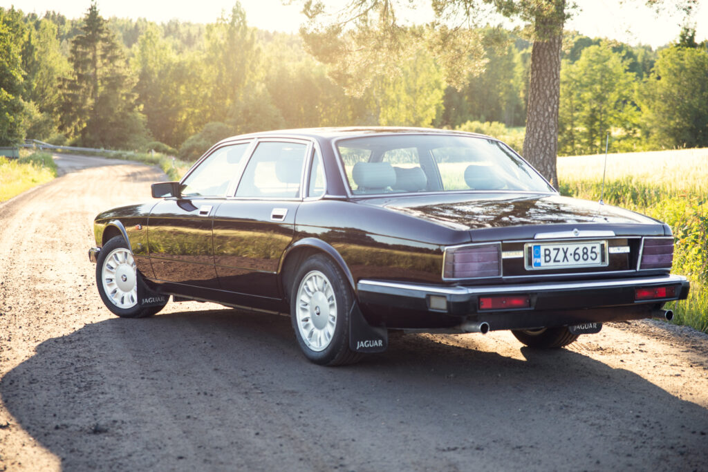 Black Jaguar sedan on rural dirt road