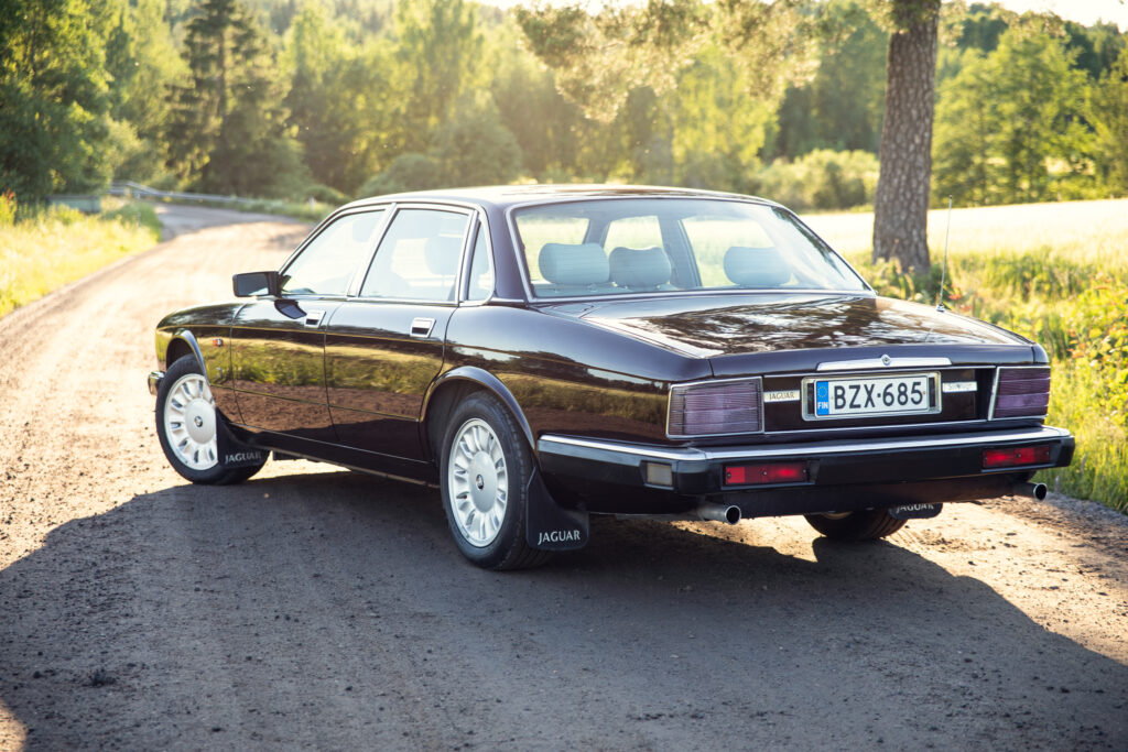Classic Jaguar sedan on sunlit rural road
