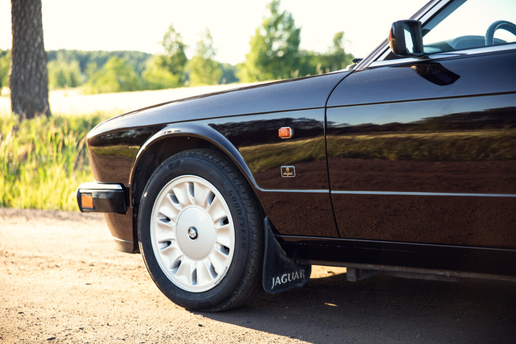 Close-up of black Jaguar car wheel and fender