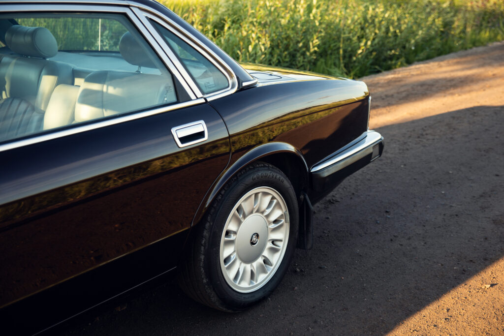 Vintage luxury sedan parked on rural dirt road
