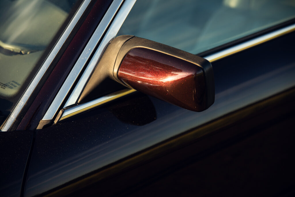 Close-up of car side mirror at sunset