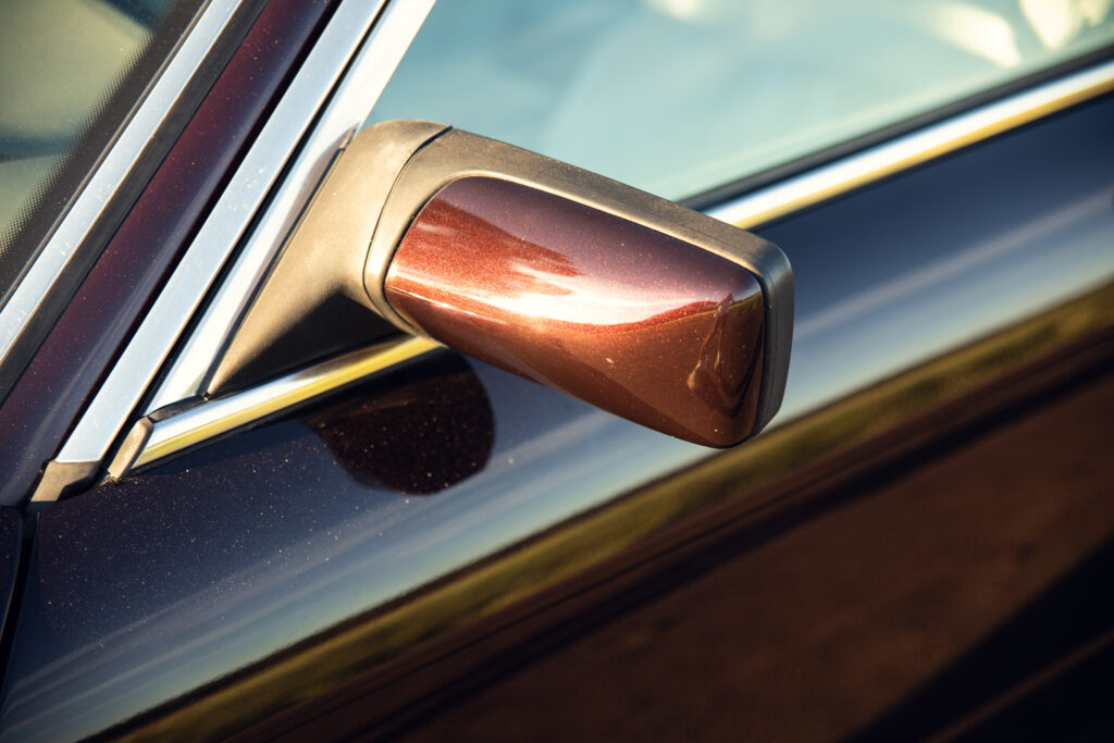 Close-up of car side mirror in sunlight