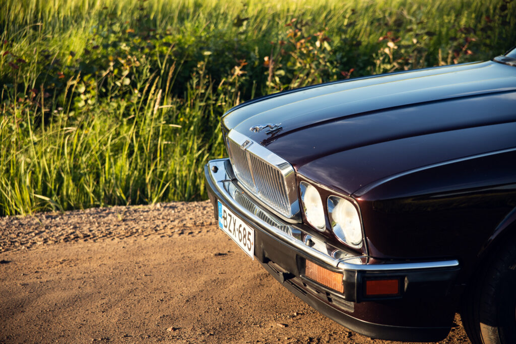 Front of vintage Jaguar on rural road