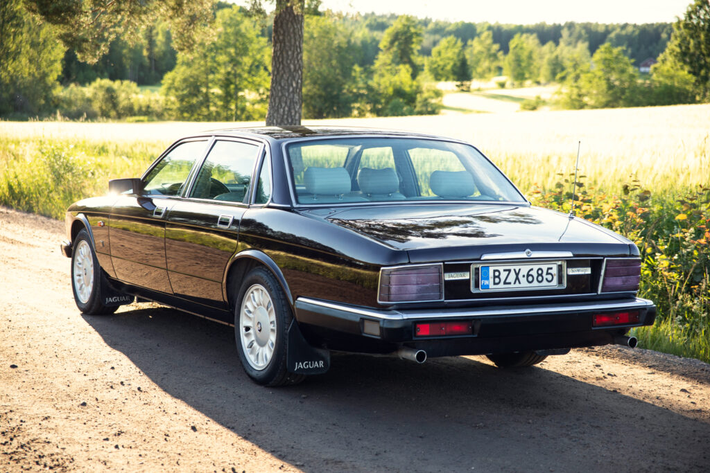 Black classic Jaguar sedan on rural road