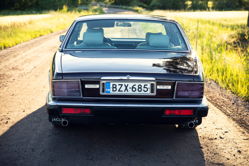 Rear view of classic Jaguar on country road
