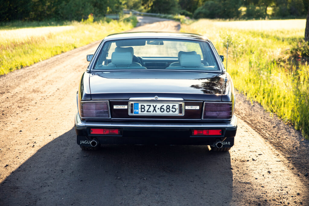 Rear view of classic Jaguar on country road